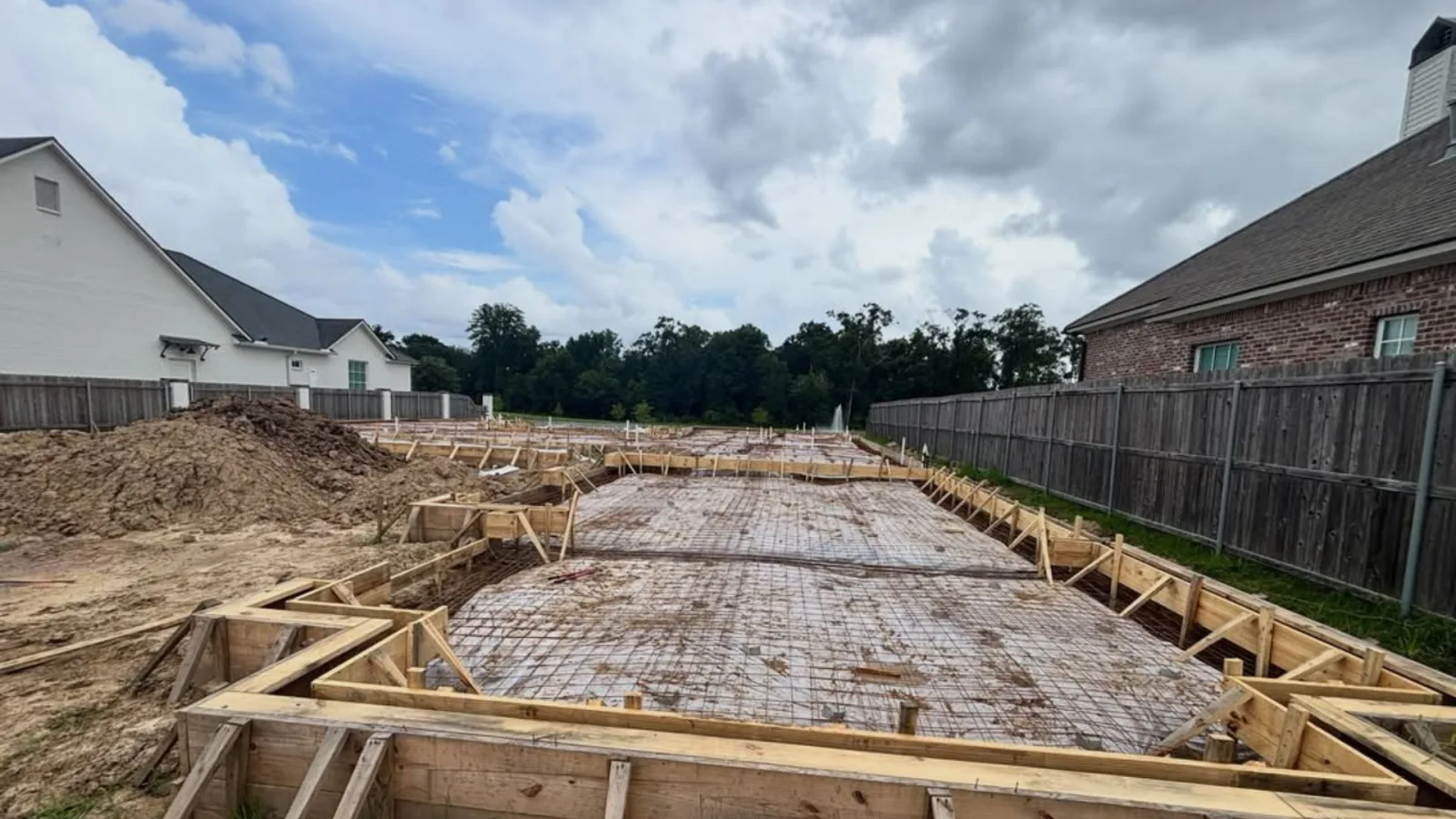 Rebar-reinforced concrete slab prepped over a vapor barrier for a backyard patio in Lafayette, Louisiana