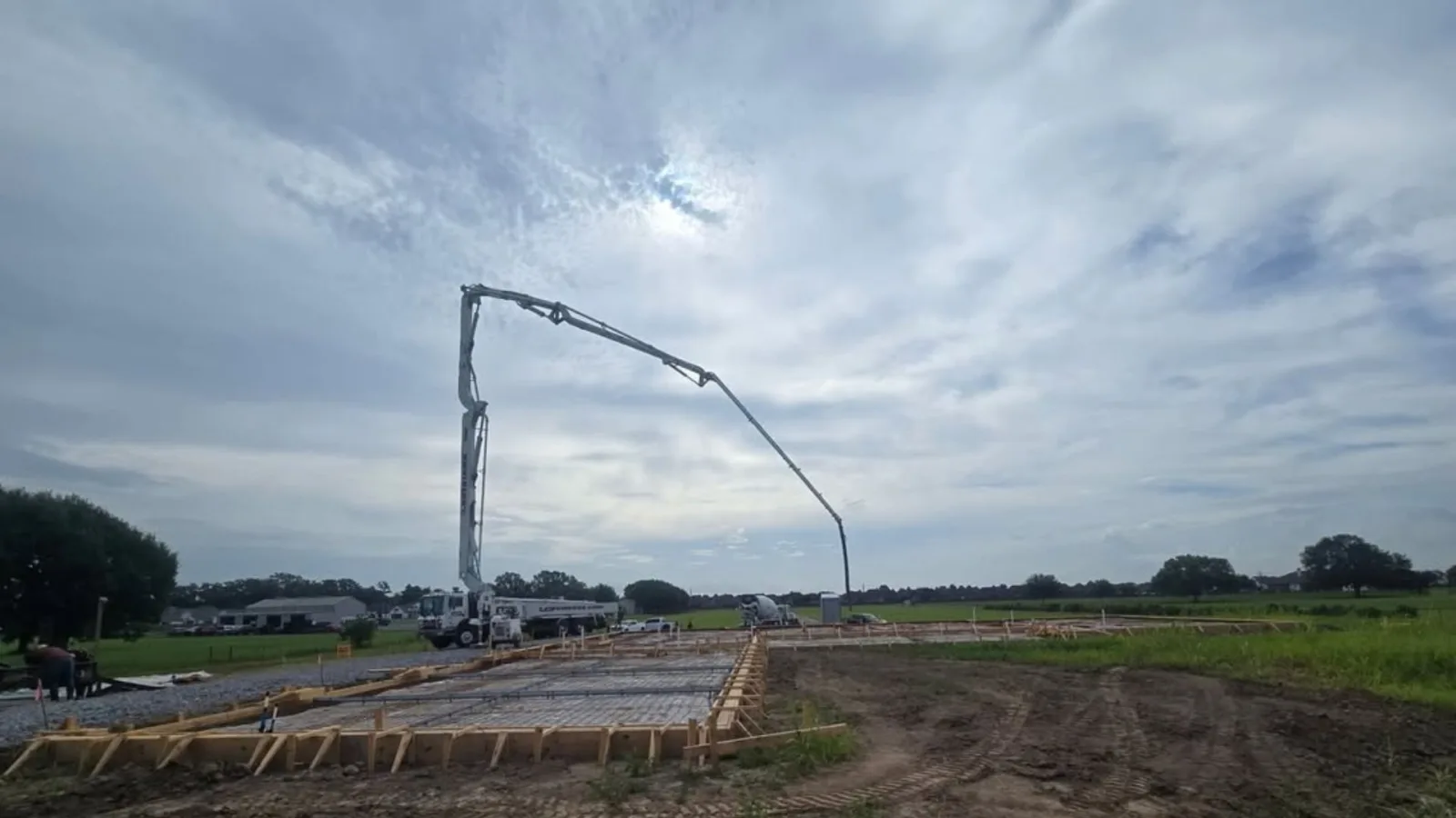 Finished concrete driveway and approach poured for a Lafayette home, shown from above with a mixer truck on site